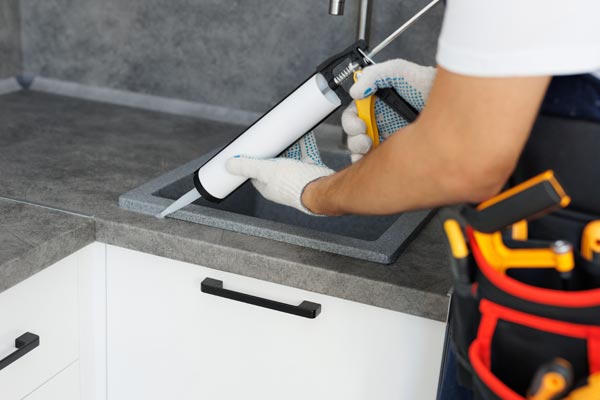 Plumber-caulking-a-sink